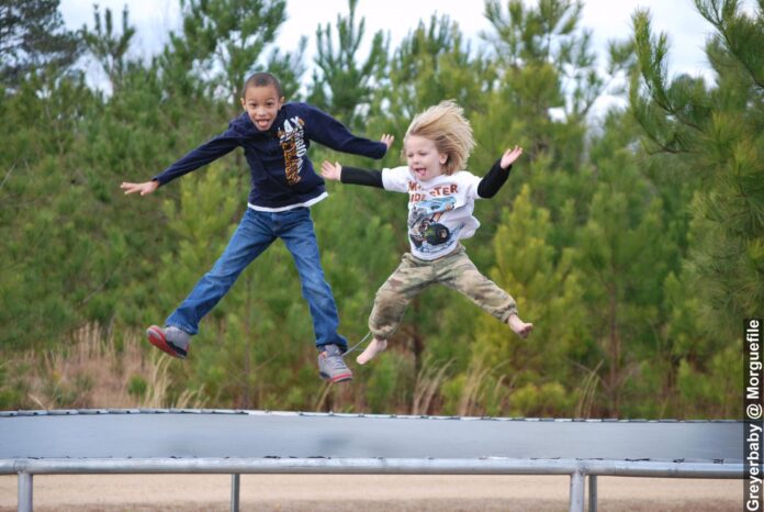 Two boys jumping on trampoline