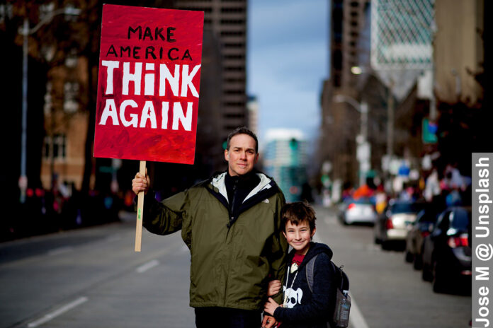 Freedom of speech is a right in America, boy and dad holding a placard protesting