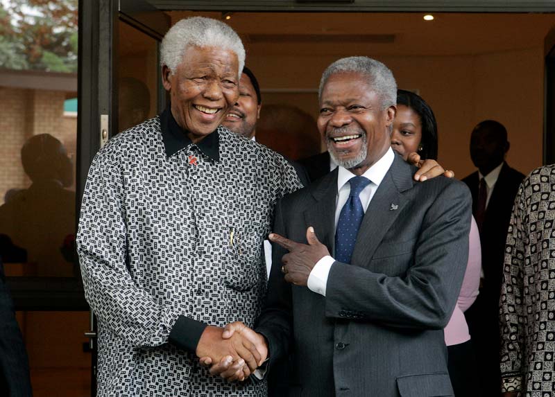 Nelson Mandela shaking hands with UN Secretary-General Kofi Annan while both smile warmly.